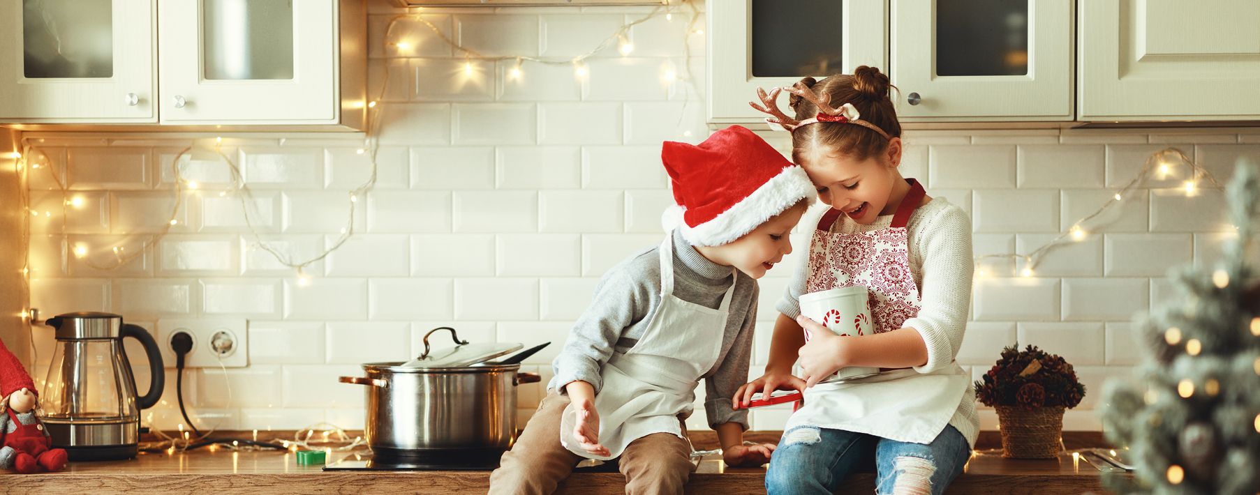 Two kids looking in a candy jar on the kitchen counter