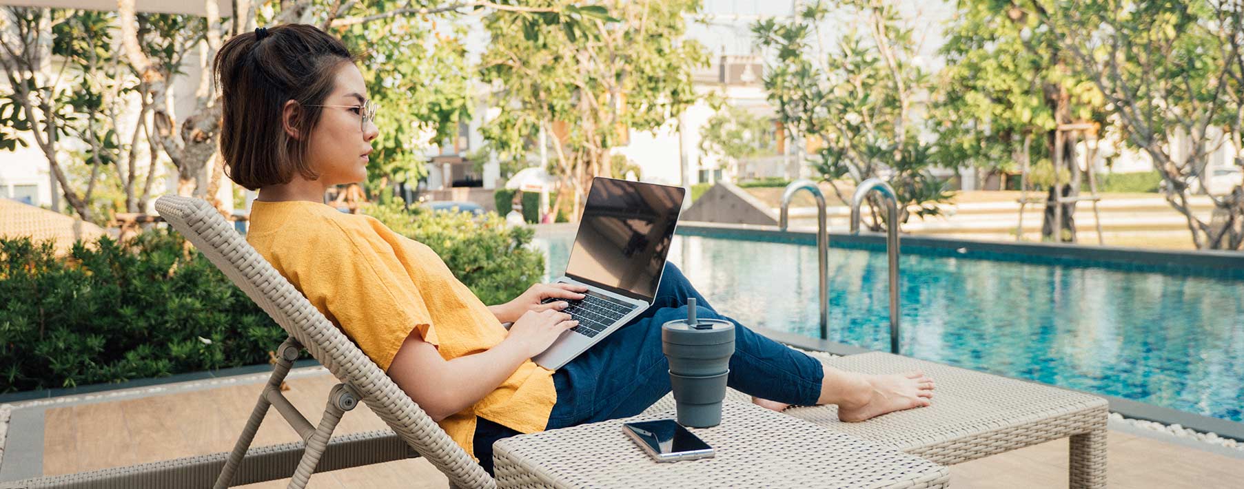 Woman using computer by a pool