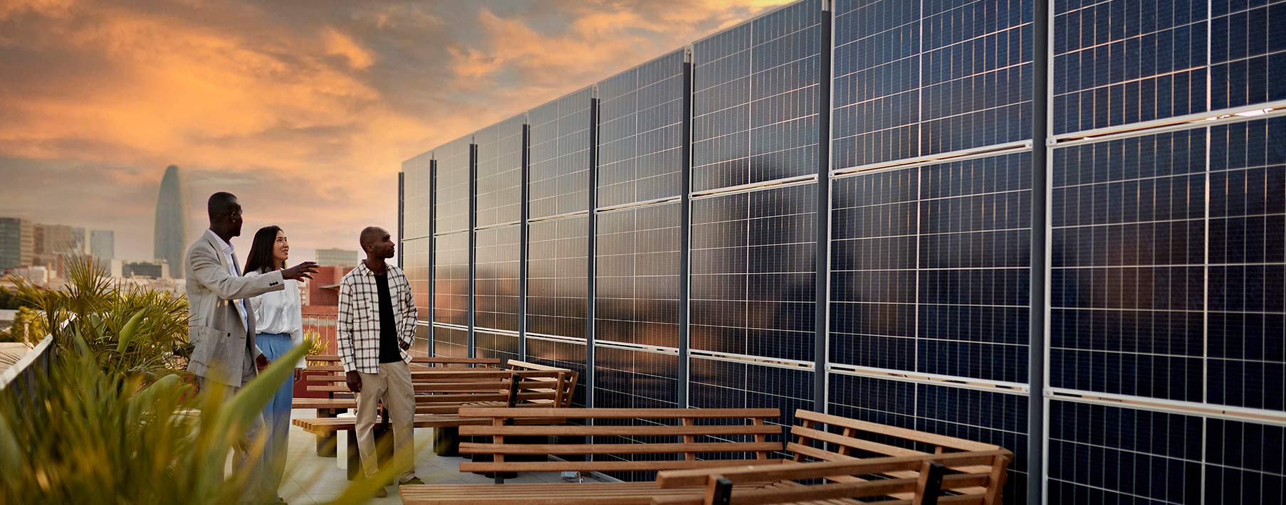 three people looking at a rooftop solar array