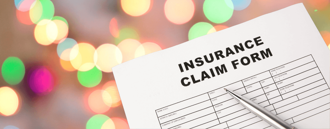 insurance home claims paper form in front of a background of blurred holiday lights