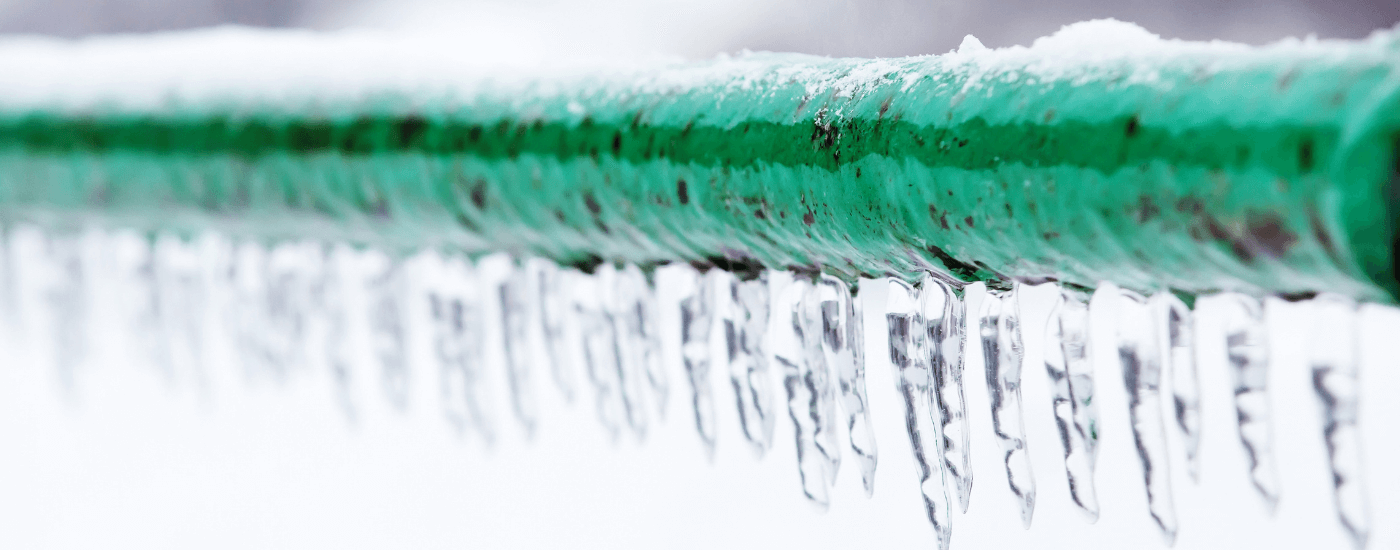 green pipe with icicles hanging from the bottom