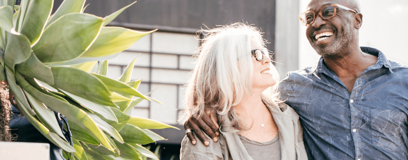 older homeowners happily walking outside of their home