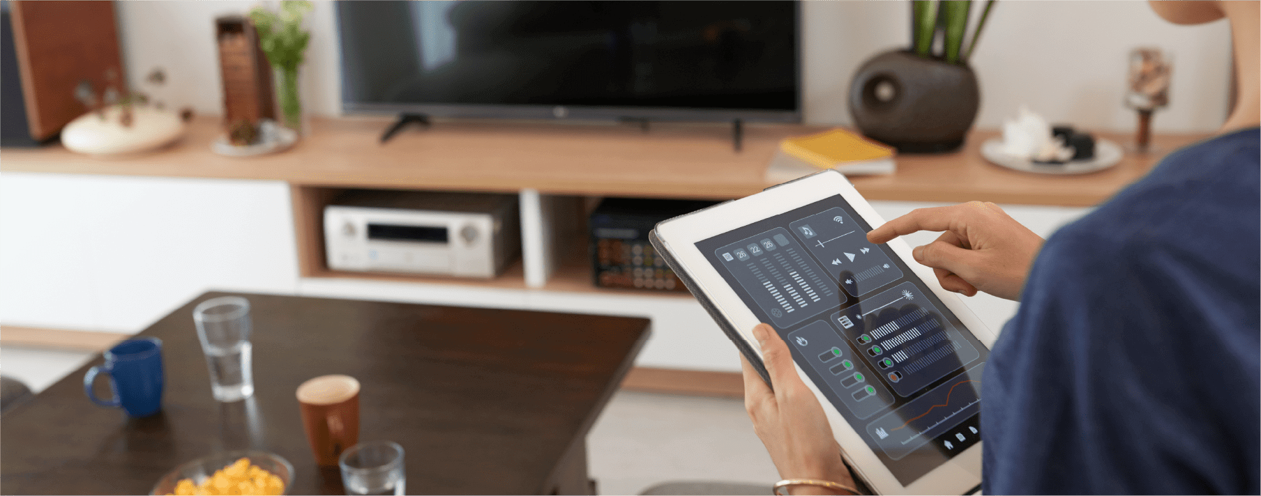 A person using a tablet in their living room to power their entertainment system