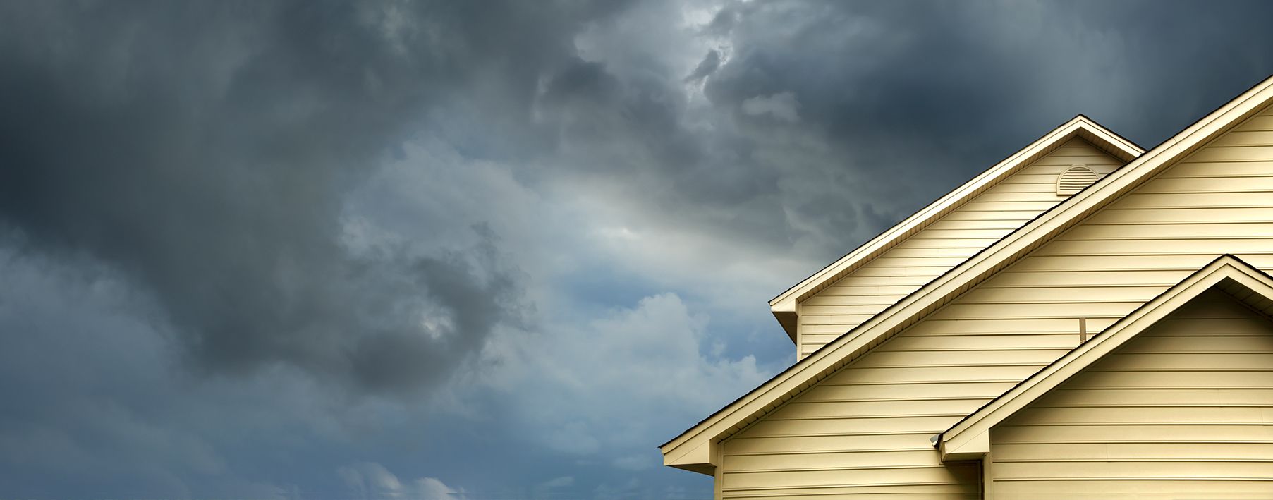 A storm coming in behind a yellow home