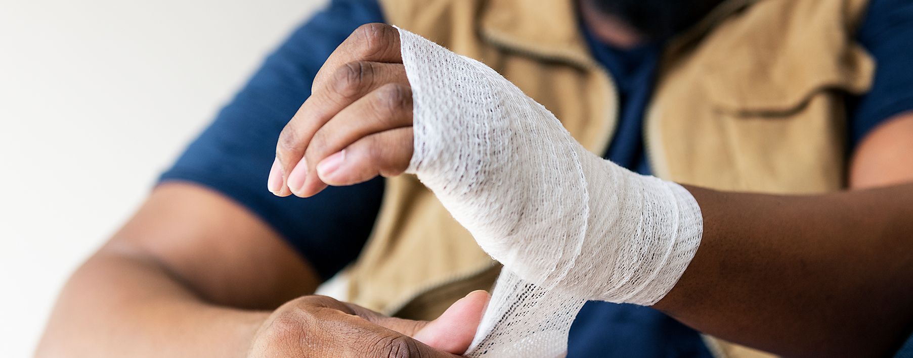 A man wrapping his wrist with white guaze