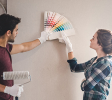 A couple looking at paint samples against a blank wall