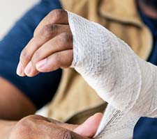 man wrapping his hand in gauze