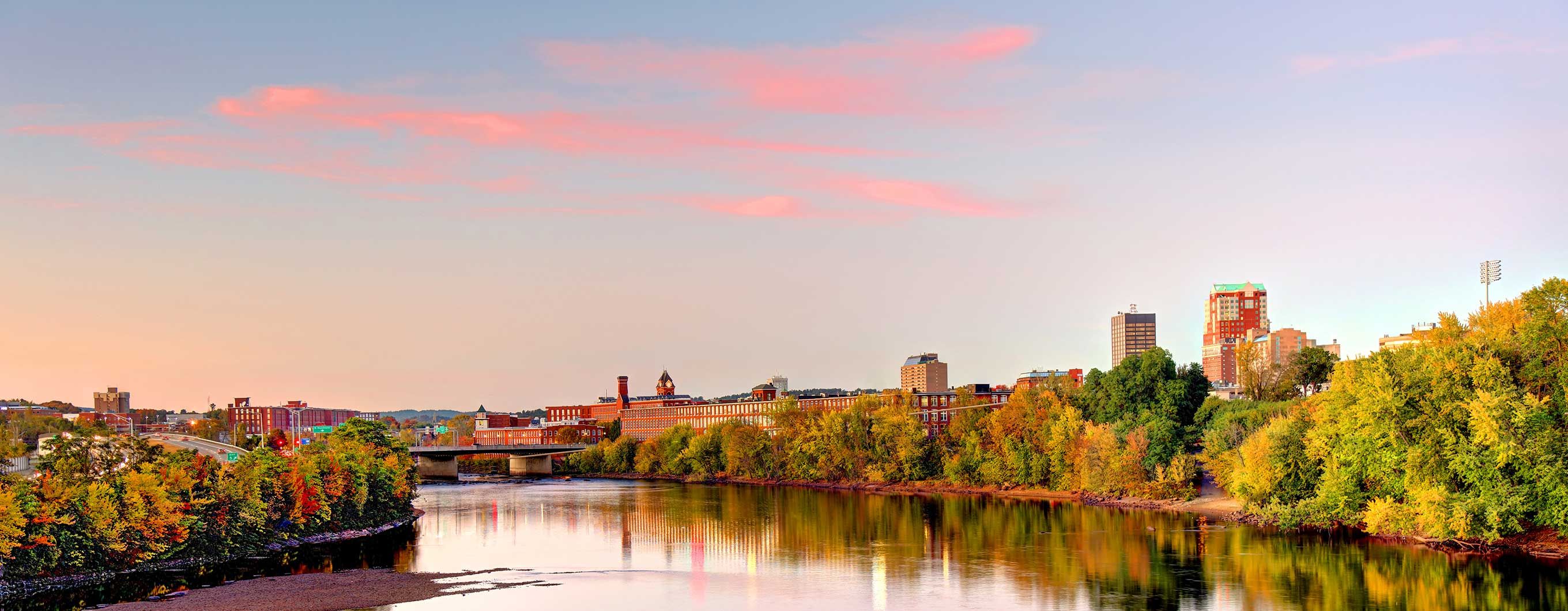 Image of new hampshire skyline surrounded by trees and a body of water