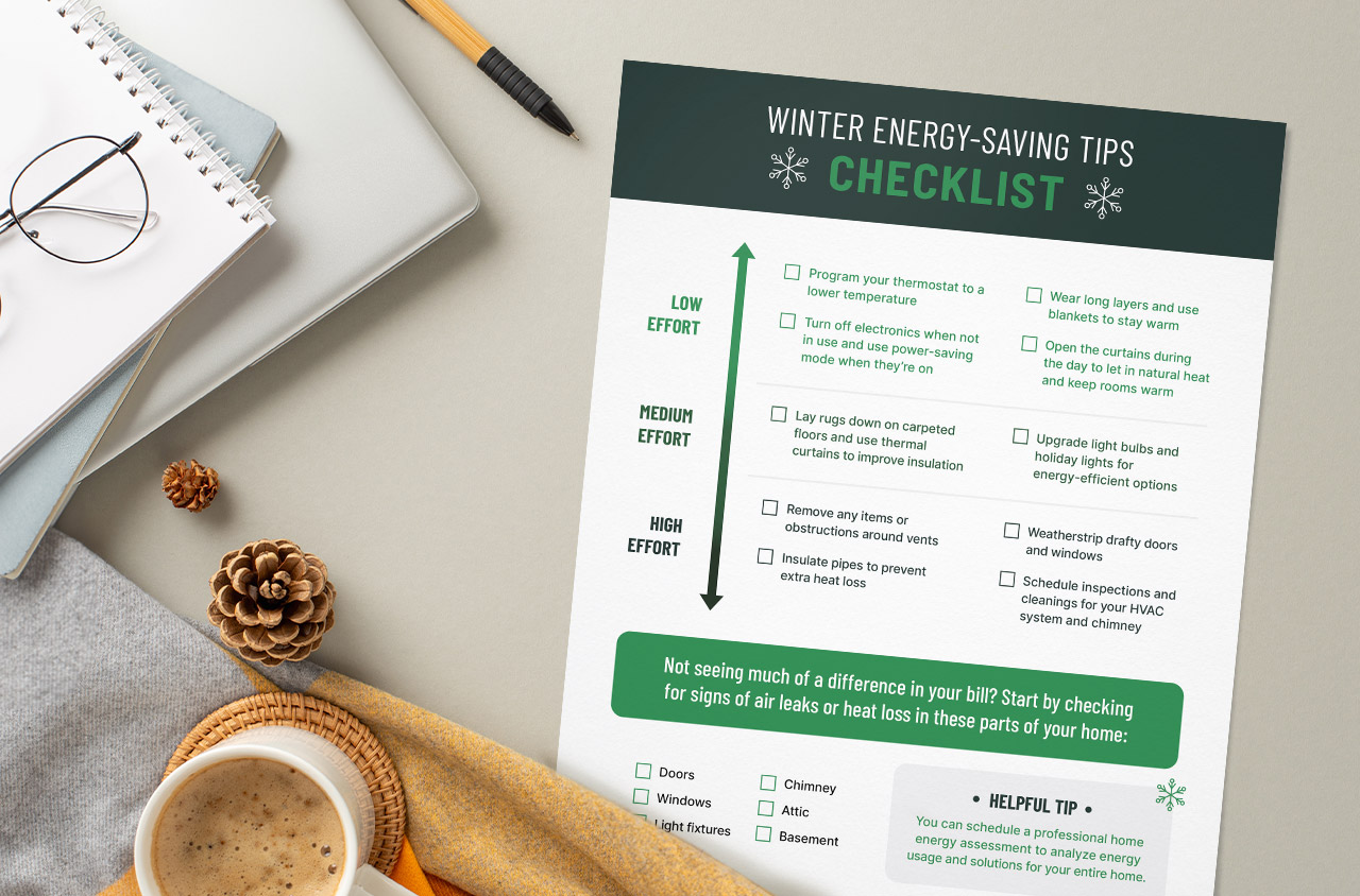 mock up of winter energy saving tips checklist next to a stack of notebooks and coffee