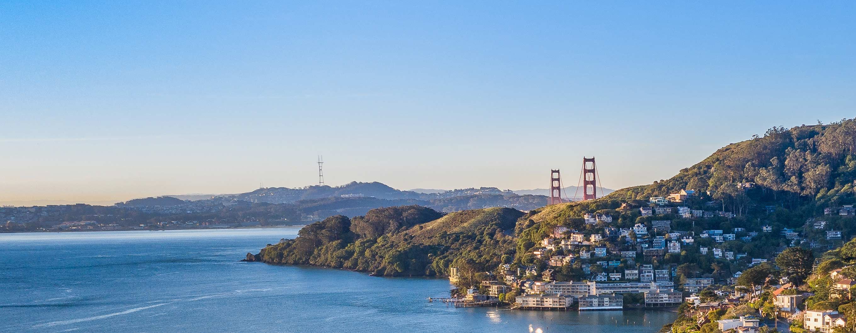 The bay area with mountains, water, homes and the golden gate bridge