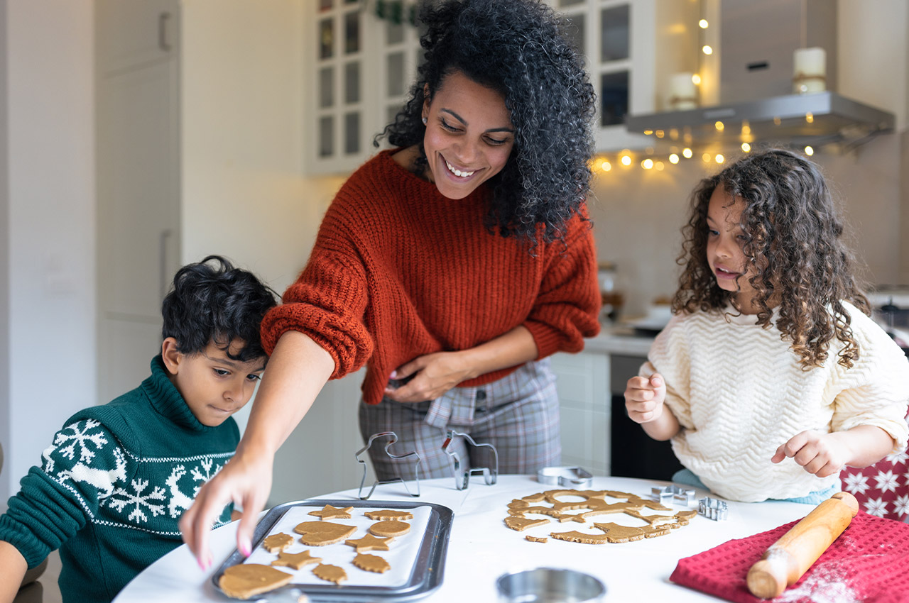 family baking holiday cookies inside the kitchen