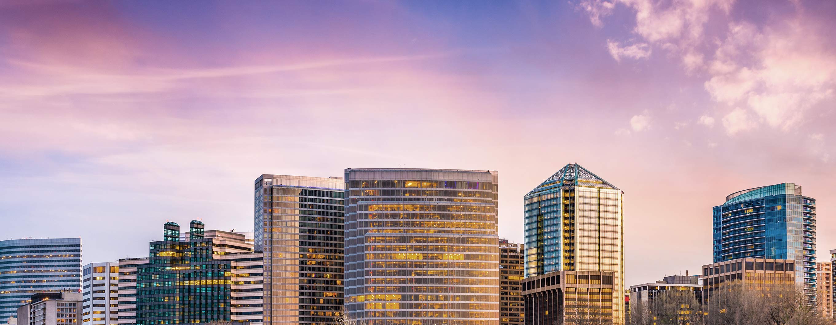 Image of the Columbus skyline with a purple and pink sky behind the buildings