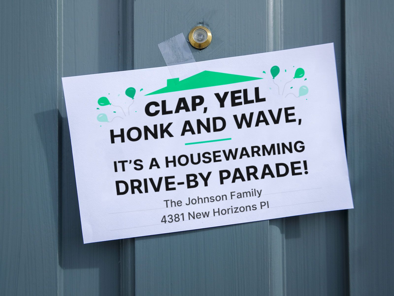 A green and white housewarming party sign taped to a blue front door