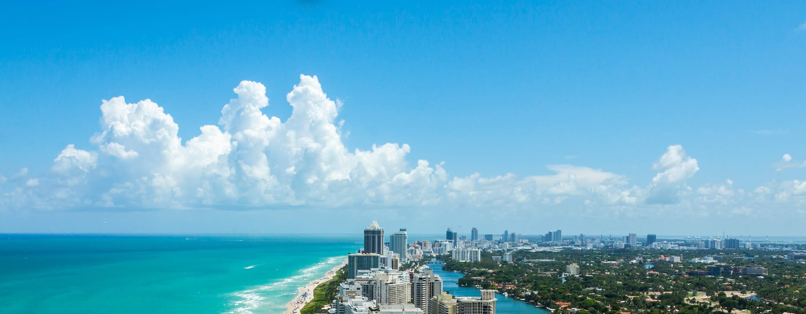 The ocean coastline in florida with buildings, trees and the beach