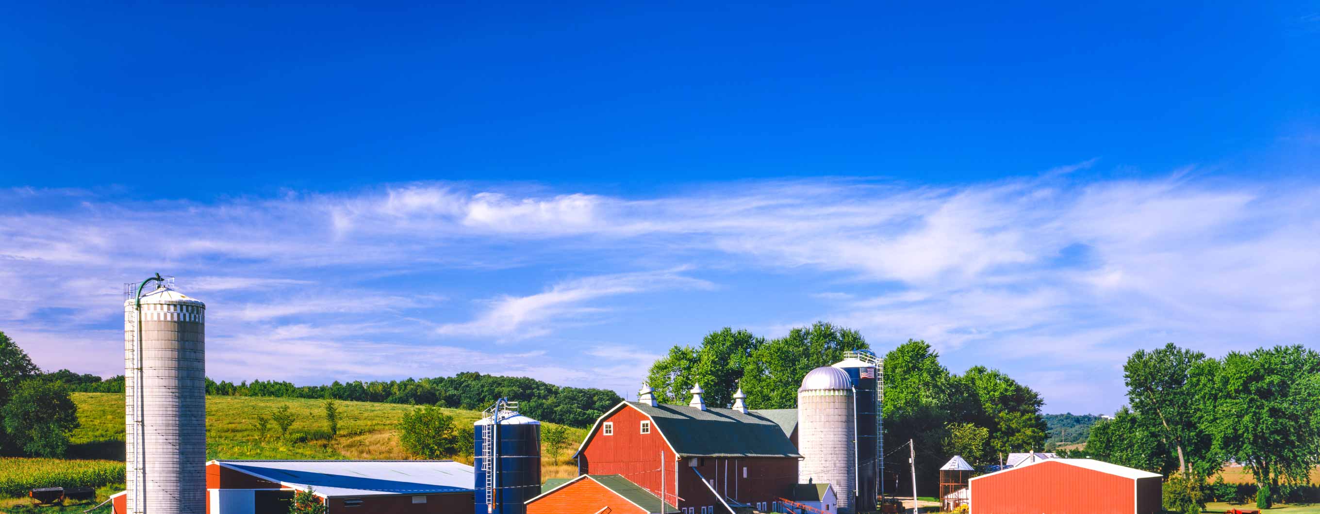 A red farmhouse on a bright, sunny day.