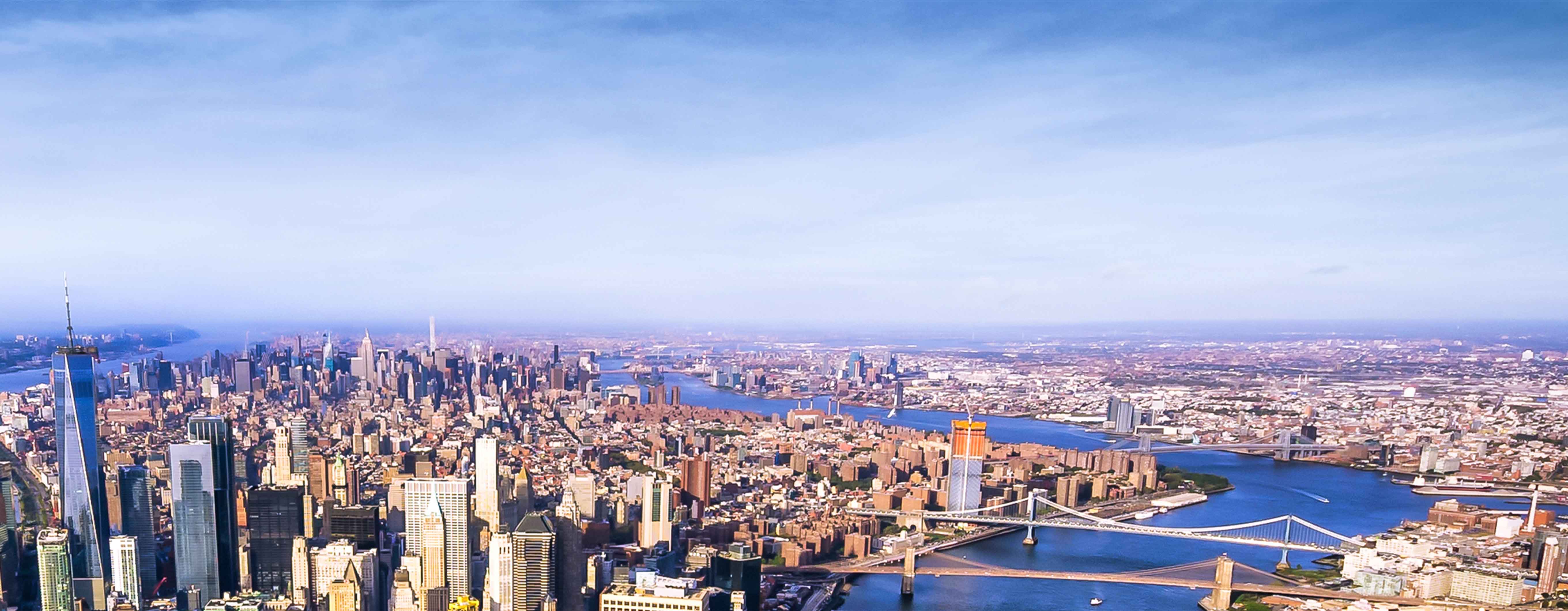 Birdseye view of the island of Manhattan with a lot of skyscrapers and bridges