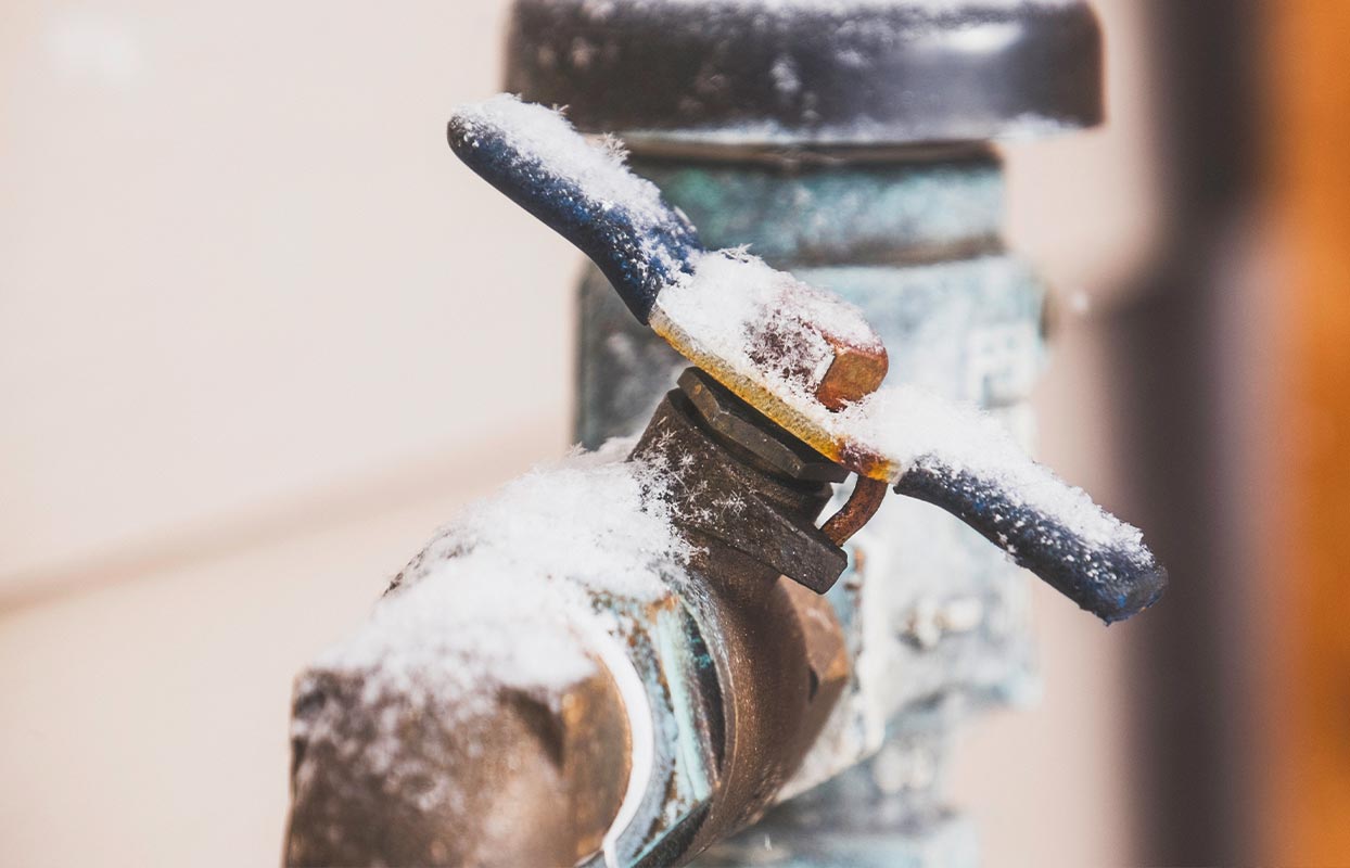 spigot outside a home with snow on top of it