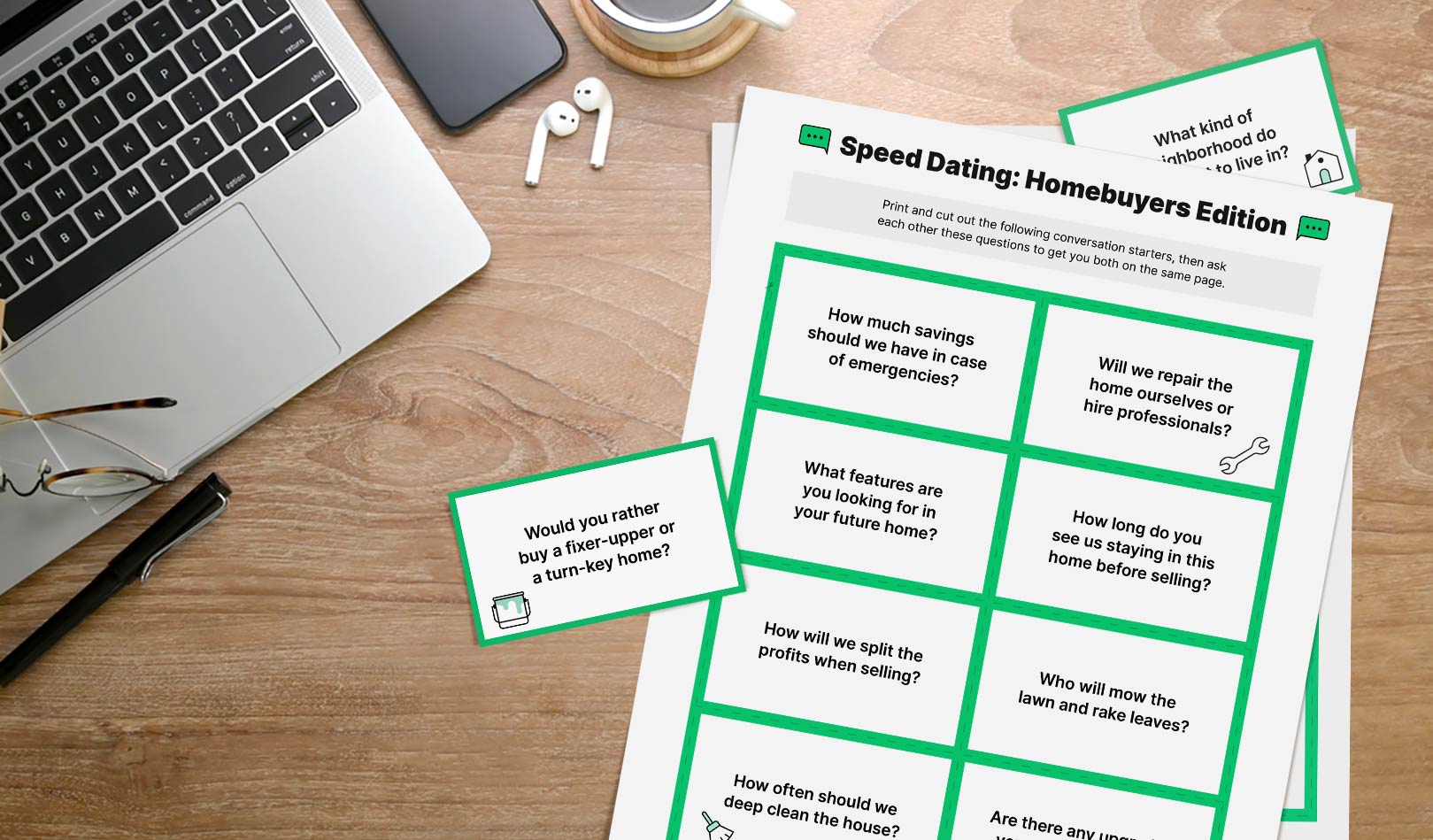 Printable speed dating cards on a desk next to a laptop and earbuds