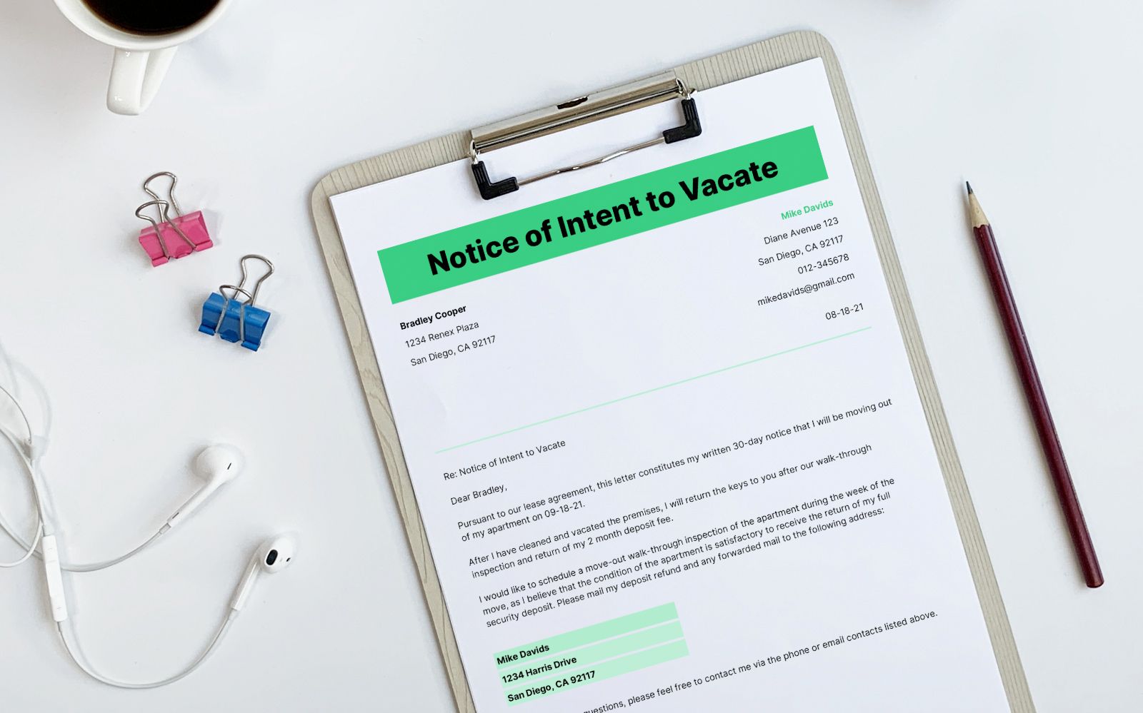 An intent to vacate letter on a clipboard sitting on a table with a pencil, paper clips and headphones nearby