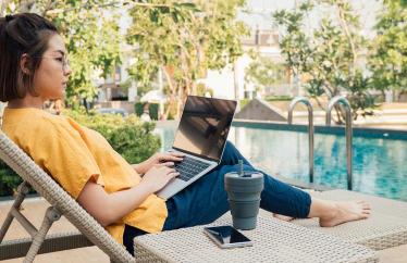 Woman using computer by a pool