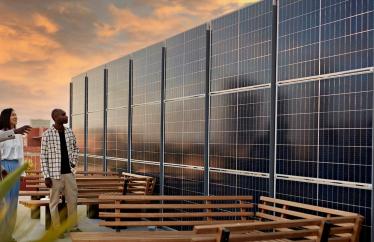 three people looking at a rooftop solar array