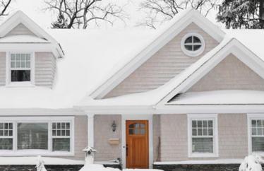 white house covered in snow and surrounded by snowy trees