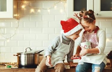 Two kids looking in a candy jar on the kitchen counter
