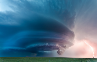 Tornado and a storm over a grassy field