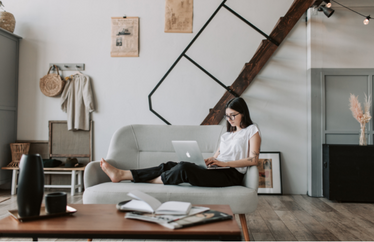 homeowner researching insurance costs on laptop while sitting on their couch