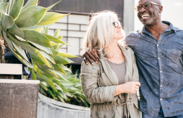 older homeowners happily walking outside of their home